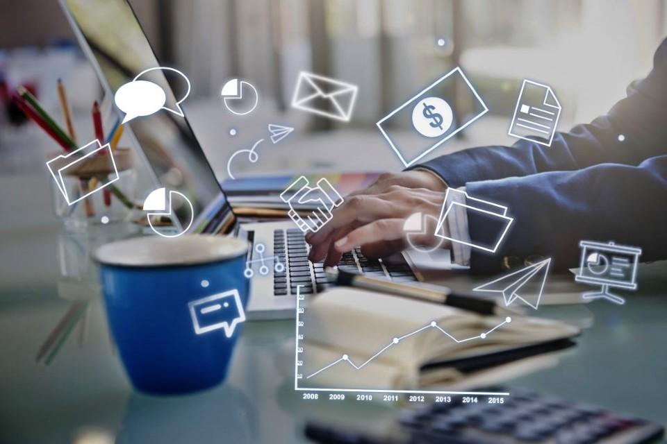 a futureistic image of a work person at a desk typing on a laptop