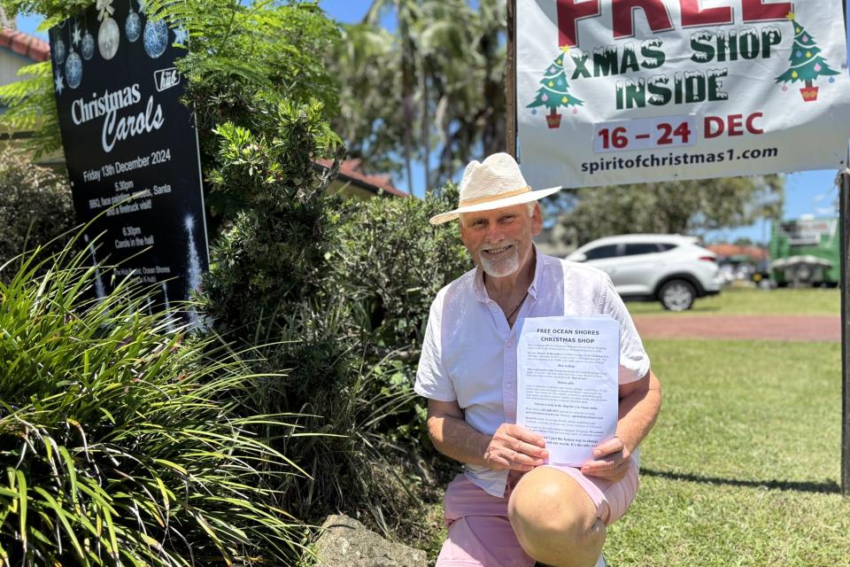 Dennis Stenson is a pillar of the Northern Rivers community pictiure kneeling with the brochure featering the upocoming free shop