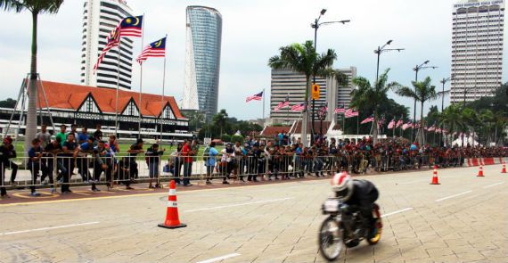 A drag bike roars past the Royal Selangor Club