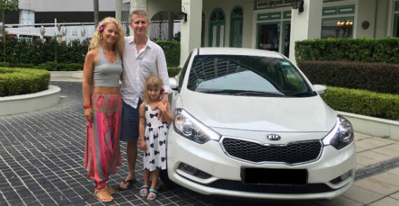 Mr and Mrs Sutehall in Malaysia with their white Kia Forte K3 AVIS